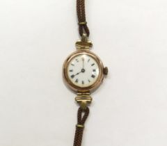A 9ct gold cased wristwatch with white enamel dial, on leather strap