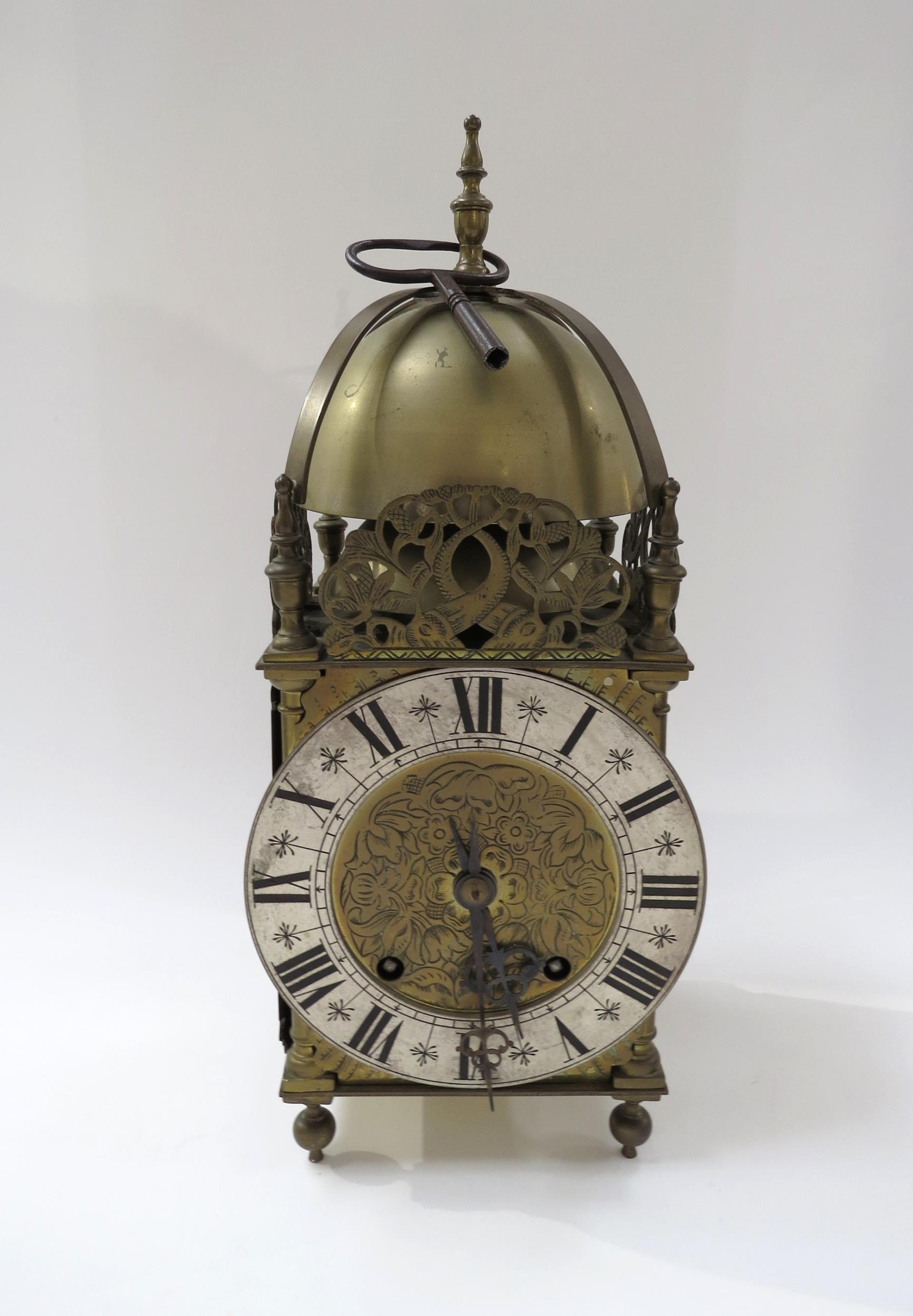 An early 20th Century brass lantern form striking clock with ting tang quaterly strike on two bells,