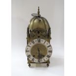 An early 20th Century brass lantern form striking clock with ting tang quaterly strike on two bells,
