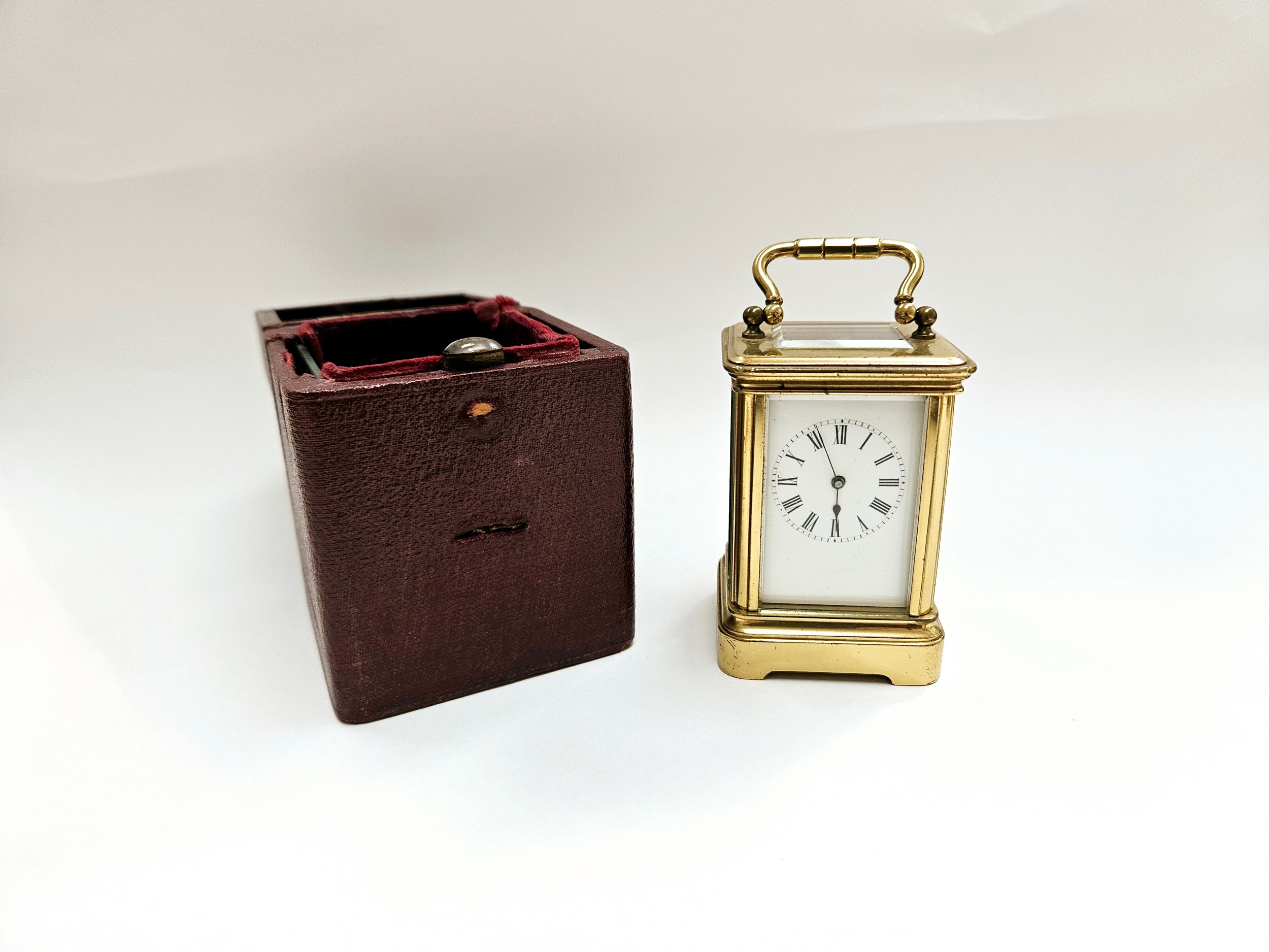 A miniature brass carriage clock with leather travel case, 8.1cm x 5cm x 4.2cm