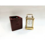 A miniature brass carriage clock with leather travel case, 8.1cm x 5cm x 4.2cm