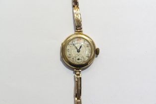 A 9ct gold ladies wristwatch with gold flexible sprung strap swiss movement