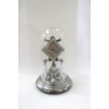 A silver coloured Olympiad anniversary clock under glass dome. 31cm tall