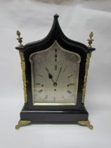 An 18th Century English ebonised bracket clock with cast brass feet, finials and side fret panels,