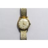 A Garrad retailed 9ct gold cased gents manual wind wristwatch. Presentation inscription to back on