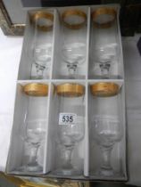 A boxed set of six glasses with gilded rims.