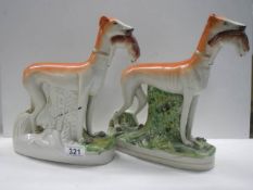 A pair of 19th century Staffordshire greyhounds with hares in mouths, 28.2 cm tall.