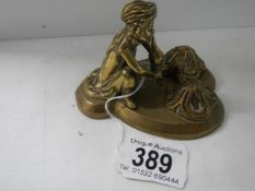 An antique brass figure of a snake charmer.
