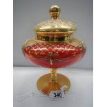 A red Murano glass lidded vase with gold and floral decoration.