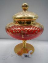 A red Murano glass lidded vase with gold and floral decoration.