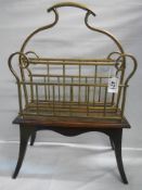 An early 20th century brass magazine rack on a wooden base.