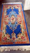 A large Chinese handmade wool rug in tones of red & blue (92cm x 207cm)