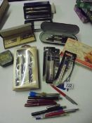 An assortment of writing implements including Parker pen sets, fountain pen with gold nib,