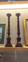 A pair of tall dark wood candlesticks