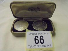 A pair of old coin cuff links in a John Smith & Son Jewellers Lincoln case.
