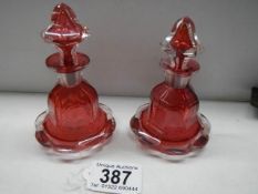 A pair of red glass perfume bottles.