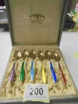 A cased set of six silver gilt and enamel coffee spoons.