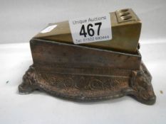 A brass cigar cutter on a cast iron base.