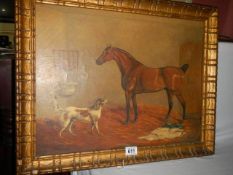 A gilt framed painting of a horse and dog in a stable.