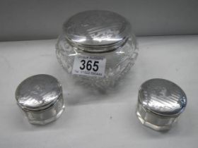 A silver topped powder bowl and 2 silver topped face cream pots.