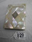 A mother of pearl wallet card case with silver cartouche.