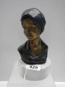 A bronze bust of a female marked P M Milano, 20cm tall.