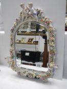 A 20th century porcelain framed mirror with cherubs and flowers, COLLECT ONLY.