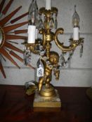An early 20th century candelabra style table lamp supported by a cherub.