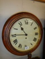 A circular mahogany school clock, in working order.