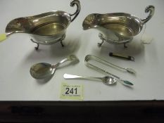 A pair of silver plate sauce boats, spoons, sugar nips etc.,