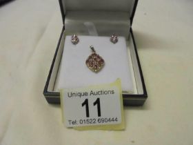 A yellow gold diamond and ruby pendant and earring set, 3.6 grams.