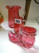 Two cranberry glass jugs and a cranberry glass boot, all in good condition.
