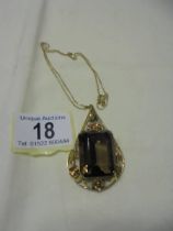A large 18ct gold pendant set large stone (possibly smoky quartz) on an 18ct (750) chain.