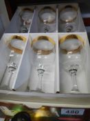 A boxed set of six good quality gilt edged wine glasses.