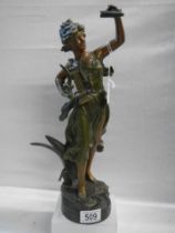 A bronzed effect figure of a female harpist.