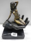 A bronze nude figure sat on an outstretched hand on a marble base, marked C Juno, 38 cm tall.