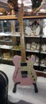 A Fender Telecaster thinline shell pink guitar with black hard case.