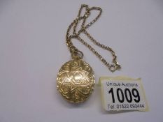 An unusual double sided yellow metal locket with domed glass on a 13.25 gramm 9ct gold chain.