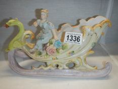 A 19th century porcelain figure on a sleigh pulled by swan.