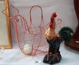 A copper coloured chicken egg basket with marble egg and a cockerel figure
