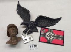 A bronze bust of a German SS soldier and a white metal eagle plaque