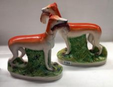 A pair of 19th century Staffordshire greyhounds with hares in mouths, 28.2 cm tall