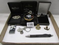 A silver Phantom mask necklace, enamel box, charm bracelet, pin badges etc.,