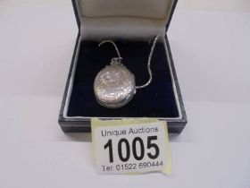 A silver locket on a silver chain,