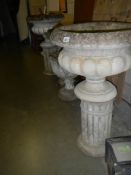 A pair of garden urns on plinths, COLLECT ONLY.
