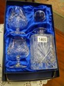 A boxed Bohemian crystal decanter and two brandy goblets.