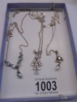 Three silver pendants.