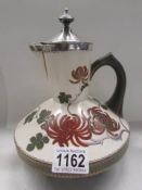 An antique Royal Doulton wine/water ewer with silver top and collar, assayed Birmingham 1883 with