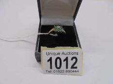 A 9ct gold diamond and green stone ring, size R, 2.1 grams.