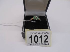 A 9ct gold diamond and green stone ring, size R, 2.1 grams.